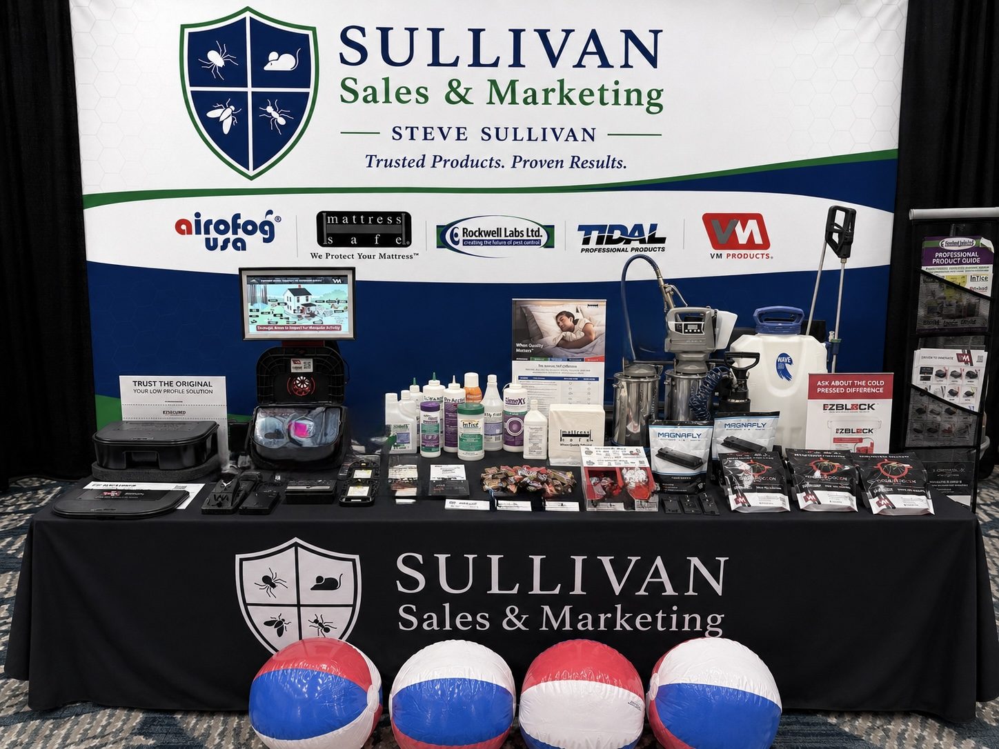 A Sullivan Sales and Marketing display table holding baits, dusts, sprayers, foggers, bait stations, and product literature
